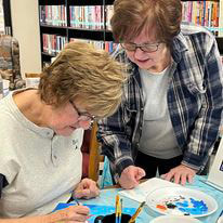 2 ladies painting and conversing at Kewaunee Public Library