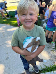 young boy with wide smile holds a bunny