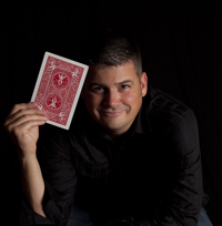 Magician Isaiah Foster holding large playing card