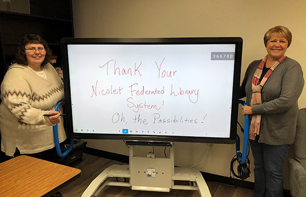 librarians standing beside interactive white board