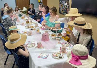 Children & adults dressed up and enjoying a tea party